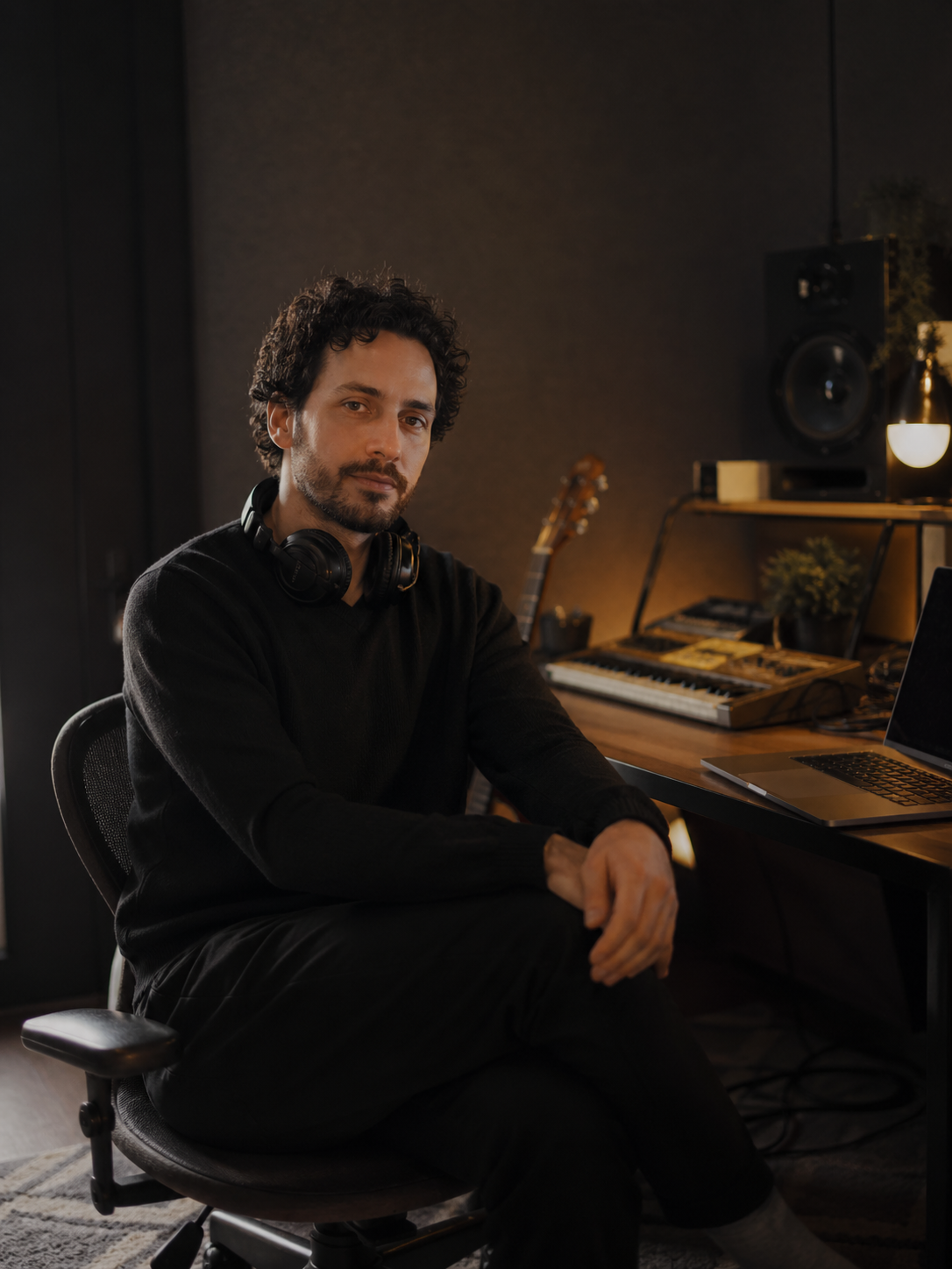 Retrato ambiental de un productor musical independiente en su espacio de trabajo.